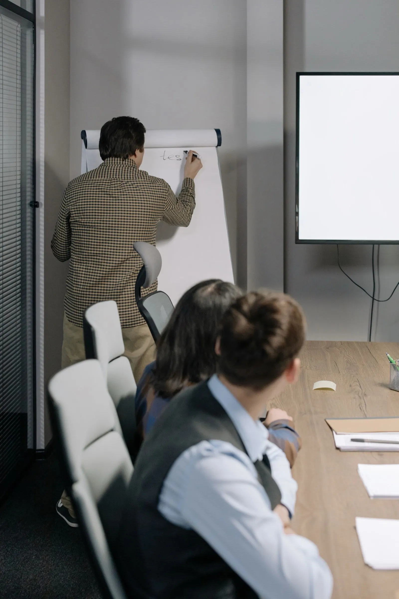 Colleagues talking around a flipchart in a meeting room